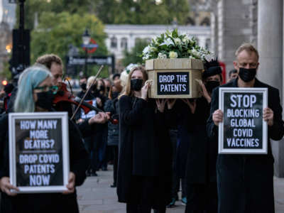 Protesters carry cardboard coffins along Whitehall during a protest against COVID-19 vaccine patents on October 12, 2021, in London, England.