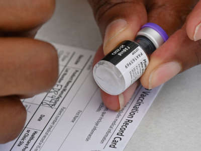 A healthcare worker fills out a COVID-19 vaccination card at a community healthcare event in Los Angeles, California, on August 11, 2021.