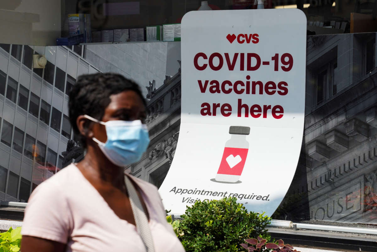 A person walks past a sign for COVID-19 vaccination at a pharmacy in New York on August 11, 2021.