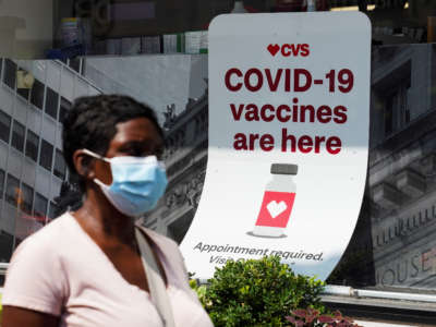 A person walks past a sign for COVID-19 vaccination at a pharmacy in New York on August 11, 2021.