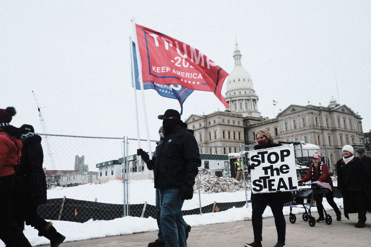 Trump Supporters march around the Michigan State Capitol Building to protest the certification of Joe Biden as the next president of the United States on January 6, 2021, in Lansing, Michigan.