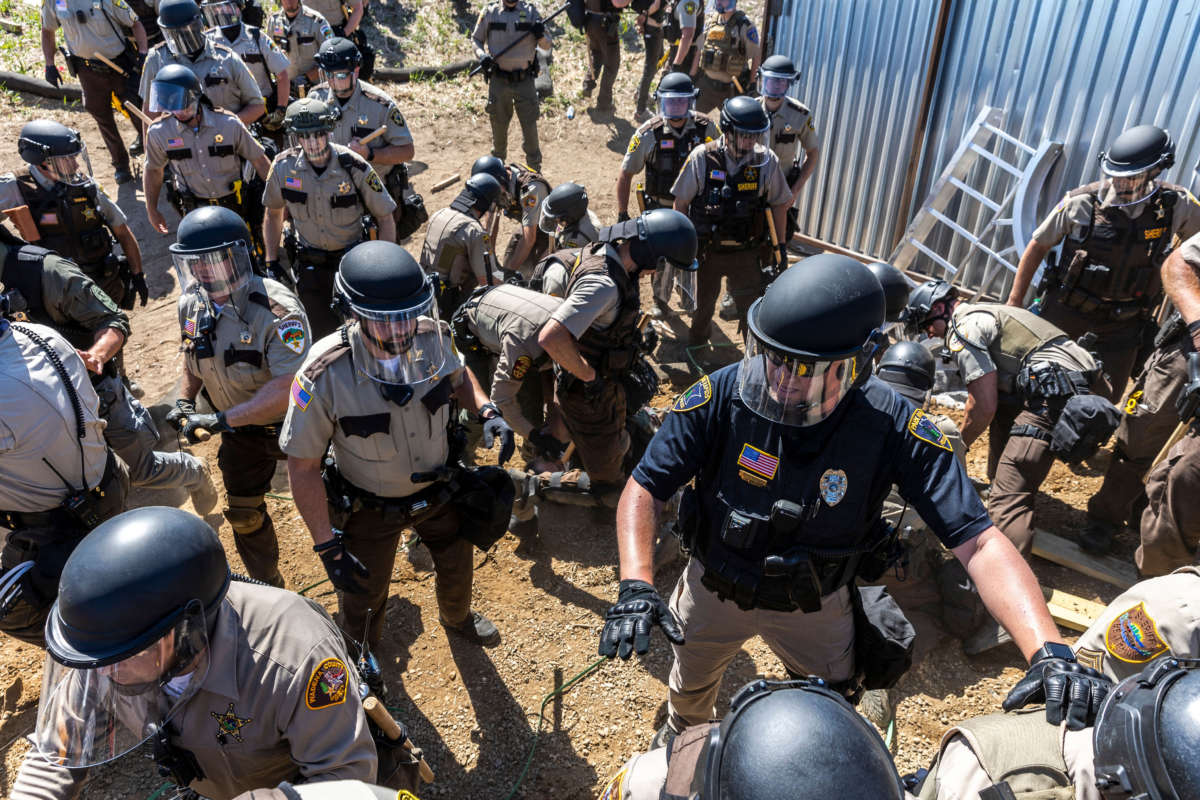 Police in riot gear arrest environmental activists at the Line 3 pipeline pumping station near the Itasca State Park, Minnesota, on June 7, 2021.