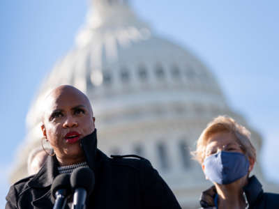 Rep. Ayanna Pressley speaks as Sen. Elizabeth Warren looks on during a press conference about student debt outside the U.S. Capitol on February 4, 2021, in Washington, D.C.