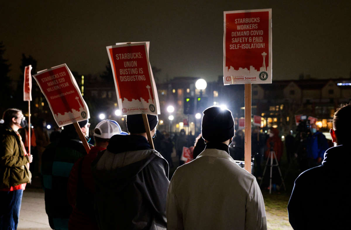 Representatives from local unions hold signs in support of workers of two Seattle Starbucks locations that announced plans to unionize, during an evening rally at Cal Anderson Park in Seattle, Washington, on January 25, 2022.