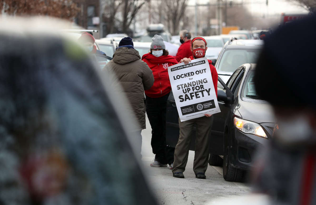 Teacher Stuart Abram holds a sign in support of the Chicago Teachers Union on January 5, 2022, the first day that classes were canceled amid the dispute over COVID-19 safety measures.