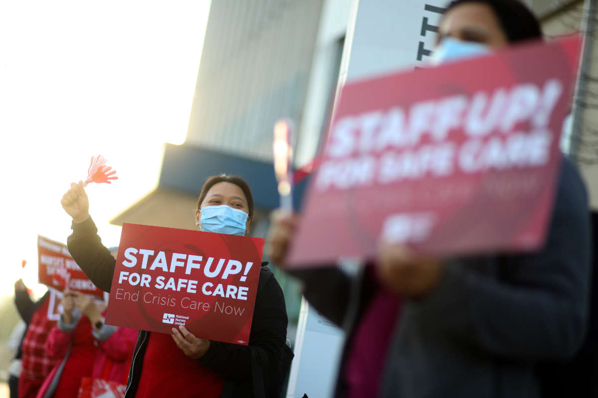 A registered nurse takes part in a rally outside the Kaiser Permanente Oakland Medical Center on January 13, 2022, in Oakland, California, in response to a California Department of Public Health decision to let asymptomatic, COVID-positive health care workers return to work without isolating or testing.