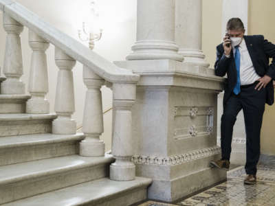 Sen. Joe Manchin on a phone call in a hallway just outside the Senate Chamber, after speaking on the floor of the Senate, on Capitol Hill on January 19, 2022, in Washington, D.C.