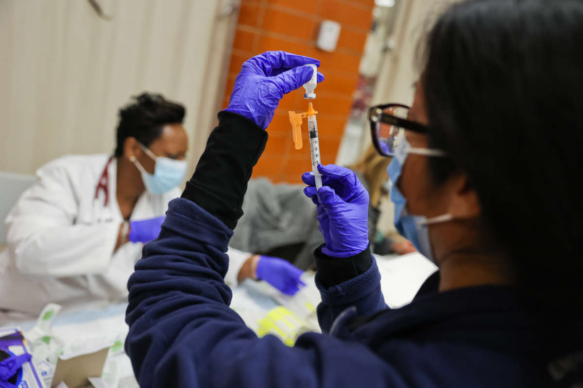 Dr. Twana Jackson prepares pediatric doses of the Pfizer COVID-19 vaccine as the Mount Sinai South Nassau Vaxmobile visits Freeport High School in Freeport, New York, on November 30, 2021.