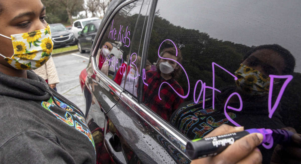 A parent decorates her car while gathering at the Leona Canyon Trailhead before participating in a car caravan demonstration in Oakland, California, on January 7, 2022. Some Oakland Unified teachers called a sickout on that day, saying they don't feel safe teaching. They're calling for two weeks of remote learning during the latest Omicron surge.