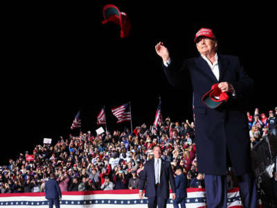 Former President Donald Trump tosses a MAGA hat to the crowd before speaking at a rally at the Canyon Moon Ranch festival grounds on January 15, 2022, in Florence, Arizona.