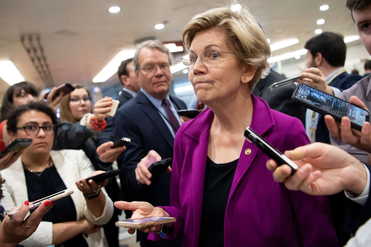 Sen. Elizabeth Warren talks with reporters as she makes her way to the Senate floor for a vote in Washington, D.C., on June 22, 2021.
