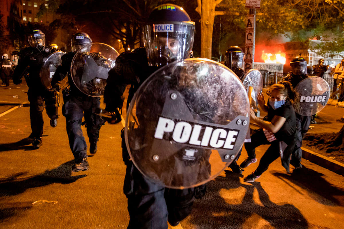 A police officer charges forward as people protest the death of George Floyd at the hands of Minneapolis police in front of the White House in Washington, D.C., on May 31, 2020.