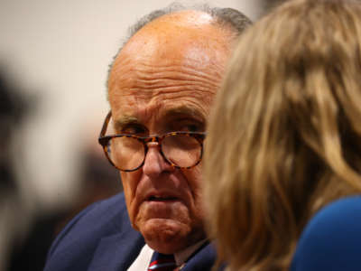 President Donald Trump's personal attorney Rudy Giuliani and Jenna Ellis, a member of the president's legal team, confer during an appearance before the Michigan House Oversight Committee on December 2, 2020, in Lansing, Michigan.