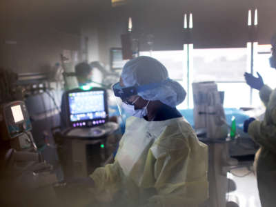 A respiratory therapist checks on a COVID-19 patient in the ICU at Rush University Medial Center on January 31, 2022, in Chicago, Illinois.