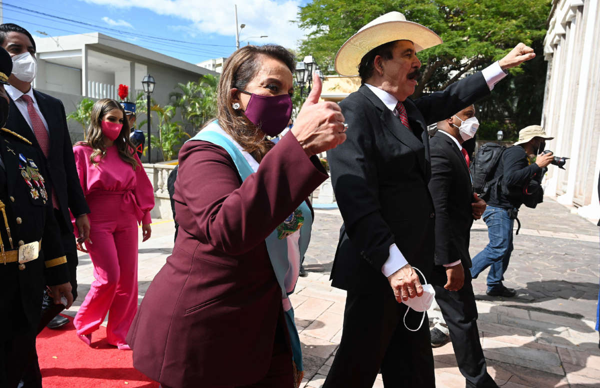 Honduran President Xiomara Castro Sarmiento Zelaya gives a thumbs-up as her husband and former Honduran President Manuel Zelaya raises his fist as they arrive at the presidential house in Tegucigalpa, Honduras, on January 27, 2022.