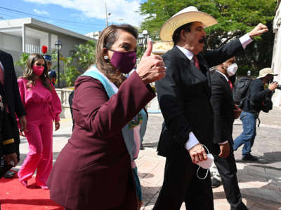 Honduran President Xiomara Castro Sarmiento Zelaya gives a thumbs-up as her husband and former Honduran President Manuel Zelaya raises his fist as they arrive at the presidential house in Tegucigalpa, Honduras, on January 27, 2022.