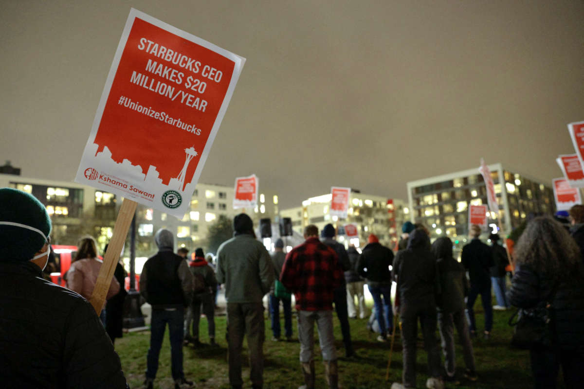 Supporters hold pro-union signs in support of workers of two Seattle Starbucks locations that announced plans to unionize, during an evening rally at Cal Anderson Park in Seattle, Washington, January 25, 2022.