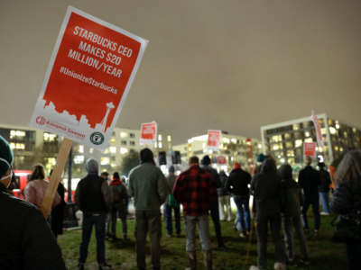 Supporters hold pro-union signs in support of workers of two Seattle Starbucks locations that announced plans to unionize, during an evening rally at Cal Anderson Park in Seattle, Washington, January 25, 2022.