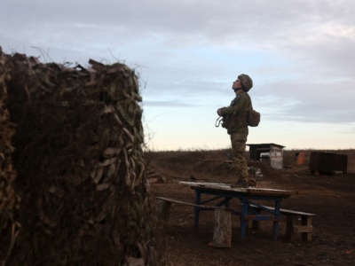 A soldier of the Ukrainian Military Forces watches on position on the front line with Russia-backed separatists not far from Novognativka village in the Donetsk region on February 19, 2022.