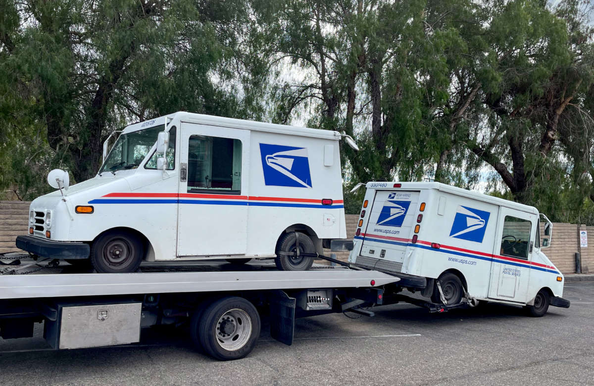 A United States Postal Service tow truck prepares to haul away two broken down delivery vehicles on February 15, 2022, in Solvang, California.