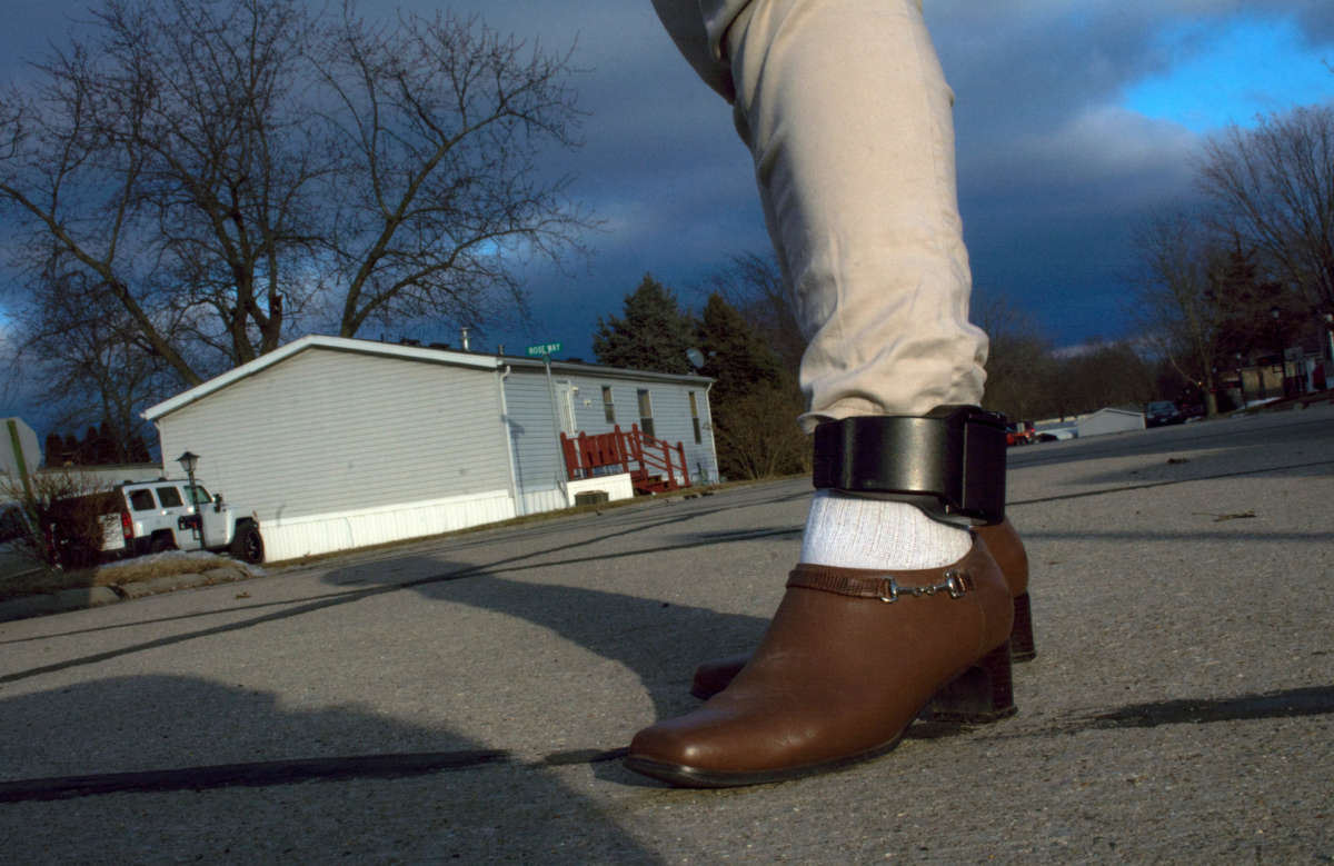 A mother displays her ankle bracelet provided by ICE as part of her asylum contact when she entered the United States, in Bloomington, Illinois, on February 16, 2019.