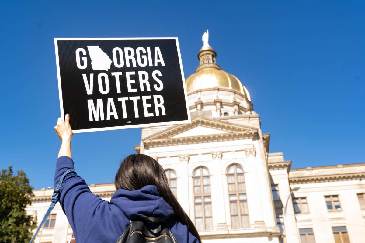 Demonstrators stand outside of the Georgia Capitol building, to oppose a bill that will add voting restrictions to the state's upcoming elections on March 3, 2021, in Atlanta, Georgia.