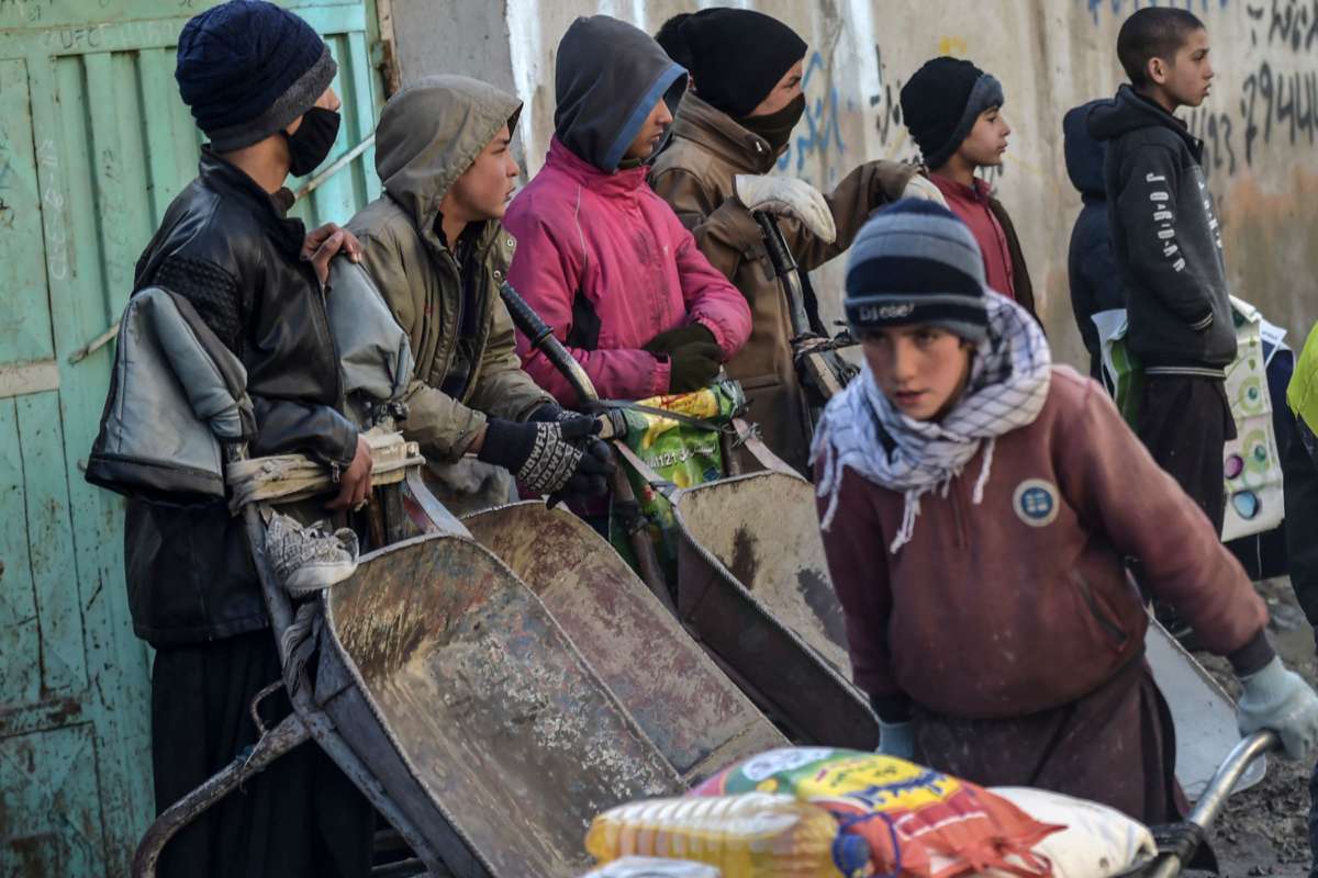 People wait to receive aid provided by a charity on the outskirts of Kabul, Afghanistan, on January 30, 2022.