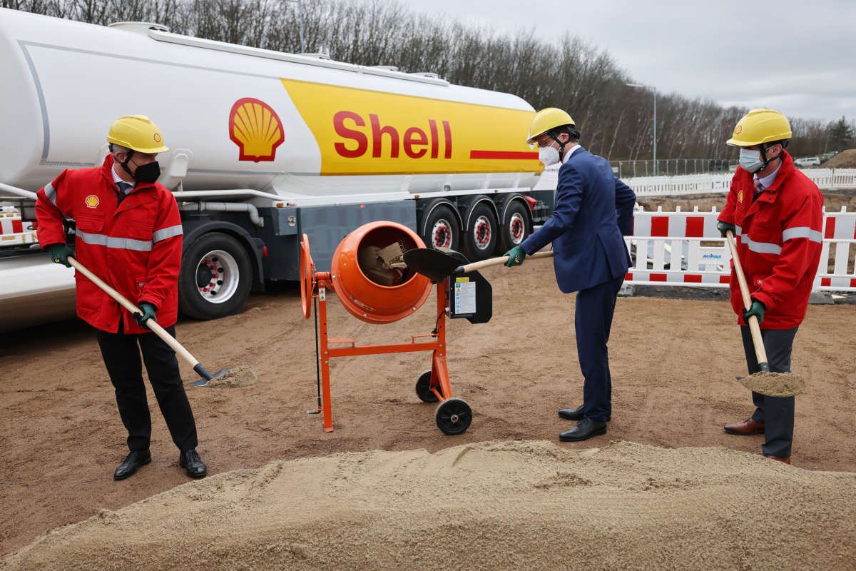 German and Shell officials shovel sand at the start of construction of a CO2-neutral bio-liquid natural gas (bio-LNG) plant on the Shell refinery site on February 9, 2022, in Cologne, Germany.