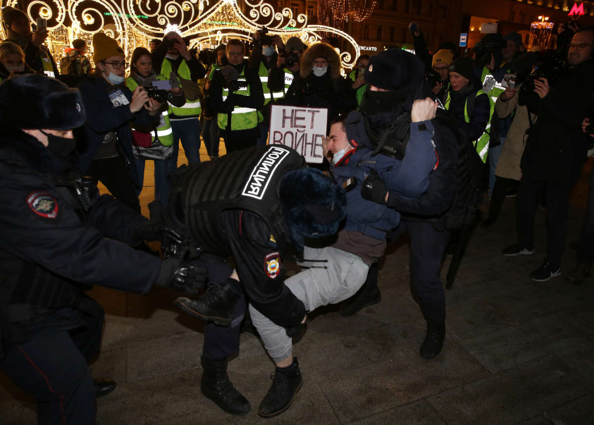 Police officers detain a man holding a placard reading "No war" during a protest at Pushkinskaya Square on February 24, 2022, in Moscow, Russia.