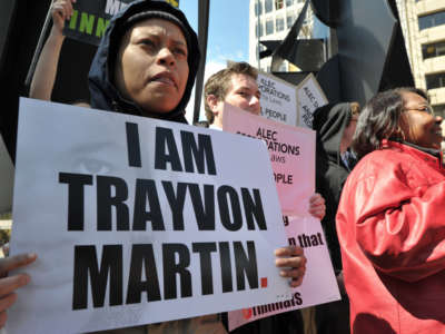 A protester carries a poster reading "I am Trayvon Martin"