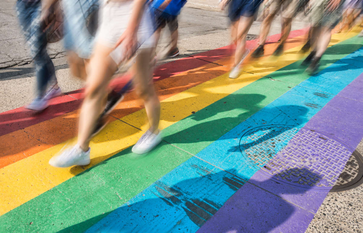 People walk along rainbow painted street