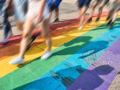 People walk along rainbow painted street