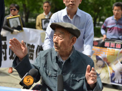 This picture taken on May 13, 2013, shows 89-year-old Zhang Shijie, a Chinese man who says he was forced to perform hard labor in Japan during World War II, speaking to the media before he and other protesters hand over their demands to the Japan side outside the Japan embassy in Beijing.