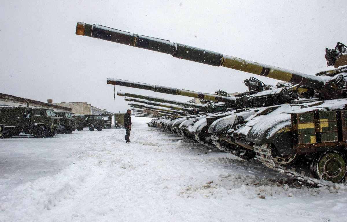 A Ukrainian Military Forces serviceman stands in front of tanks of the 92nd separate mechanized brigade of Ukrainian Armed Forces, parked in their base near Klugino-Bashkirivka village, in the Kharkiv region on January 31, 2022.