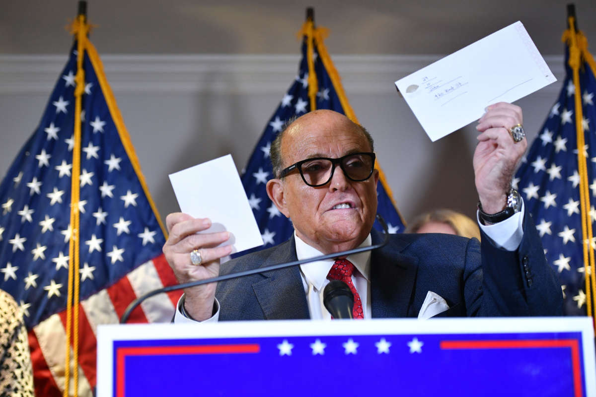 Trump's personal lawyer Rudy Giuliani holds a ballot envelope as he speaks during a press conference at the Republican National Committee headquarters in Washington, D.C., on November 19, 2020.