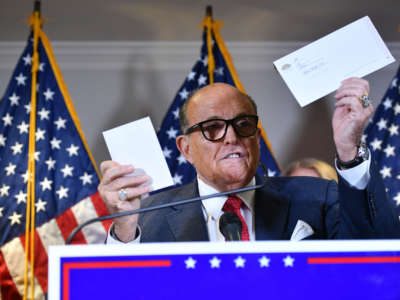 Trump's personal lawyer Rudy Giuliani holds a ballot envelope as he speaks during a press conference at the Republican National Committee headquarters in Washington, D.C., on November 19, 2020.