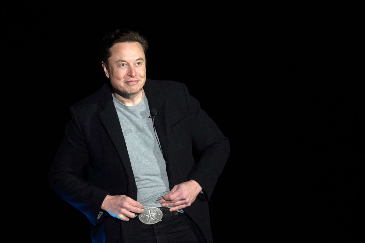 Elon Musk shows his Texas belt buckle as he speaks during a press conference at SpaceX's Starbase facility near Boca Chica Village in South Texas on February 10, 2022.