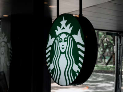 A Starbucks sign is seen hanging in storefront