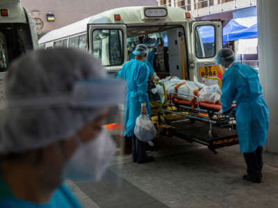 A person is transferred onto a bus outside Queen Elizabeth Hospital in Hong Kong on March 10, 2022, as the government announced the hospital will be used only for COVID-19 patients.