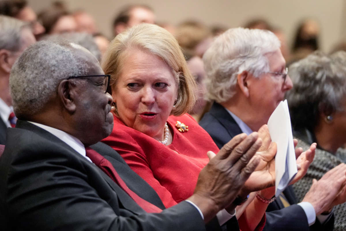 Associate Supreme Court Justice Clarence Thomas, left, sits with his wife and conservative activist Virginia Thomas while he waits to speak at the Heritage Foundation on October 21, 2021, in Washington, D.C.
