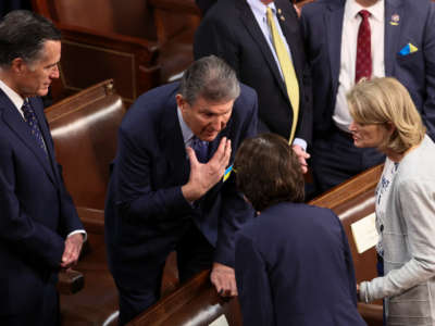 Sen. Joe Manchin talks with Senators Mitt Romney, Susan Collins and Lisa Murkowski before President Joe Biden delivers the State of the Union address during a joint session of Congress in the U.S. Capitol’s House Chamber on March 1, 2022, in Washington, D.C.