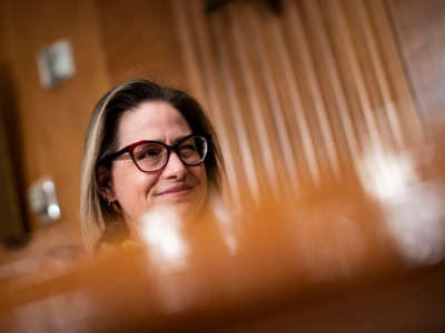 Sen. Kyrsten Sinema listens during a Senate Homeland Security and Governmental Affairs Committee confirmation hearing on February 1, 2022, in Washington, D.C.