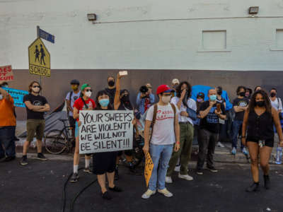 Services Not Sweeps coalition members surround a tent to stop city workers from removing it during a homeless encampment sweep on Cherokee Avenue on August 26, 2020, in Los Angeles, California.