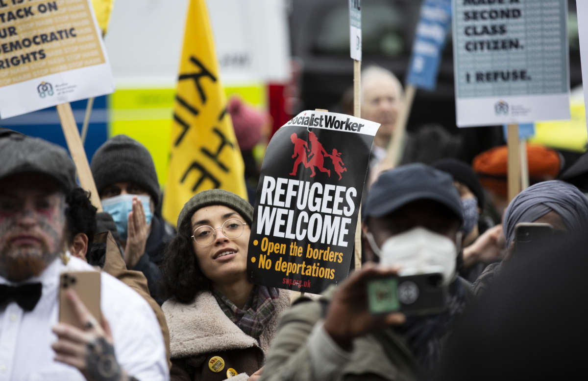 People take part in a 'Refugees Welcome' protest in demand of the withdrawal of the bill that criminalizes entering the country illegally to seek asylum, outside the parliament building in London, United Kingdom, on January 27, 2022.