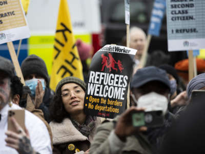 People take part in a 'Refugees Welcome' protest in demand of the withdrawal of the bill that criminalizes entering the country illegally to seek asylum, outside the parliament building in London, United Kingdom, on January 27, 2022.