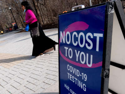 A person walks past a COVID-19 testing location in Arlington, Virginia, on March 16, 2022.