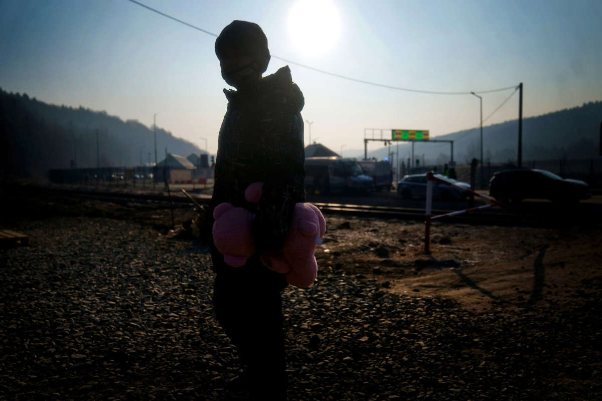 A young boy from Ukraine holds a pink teddy bear after crossing over a border point with his family in Kroscienko, in southeast Poland on March 19, 2022.