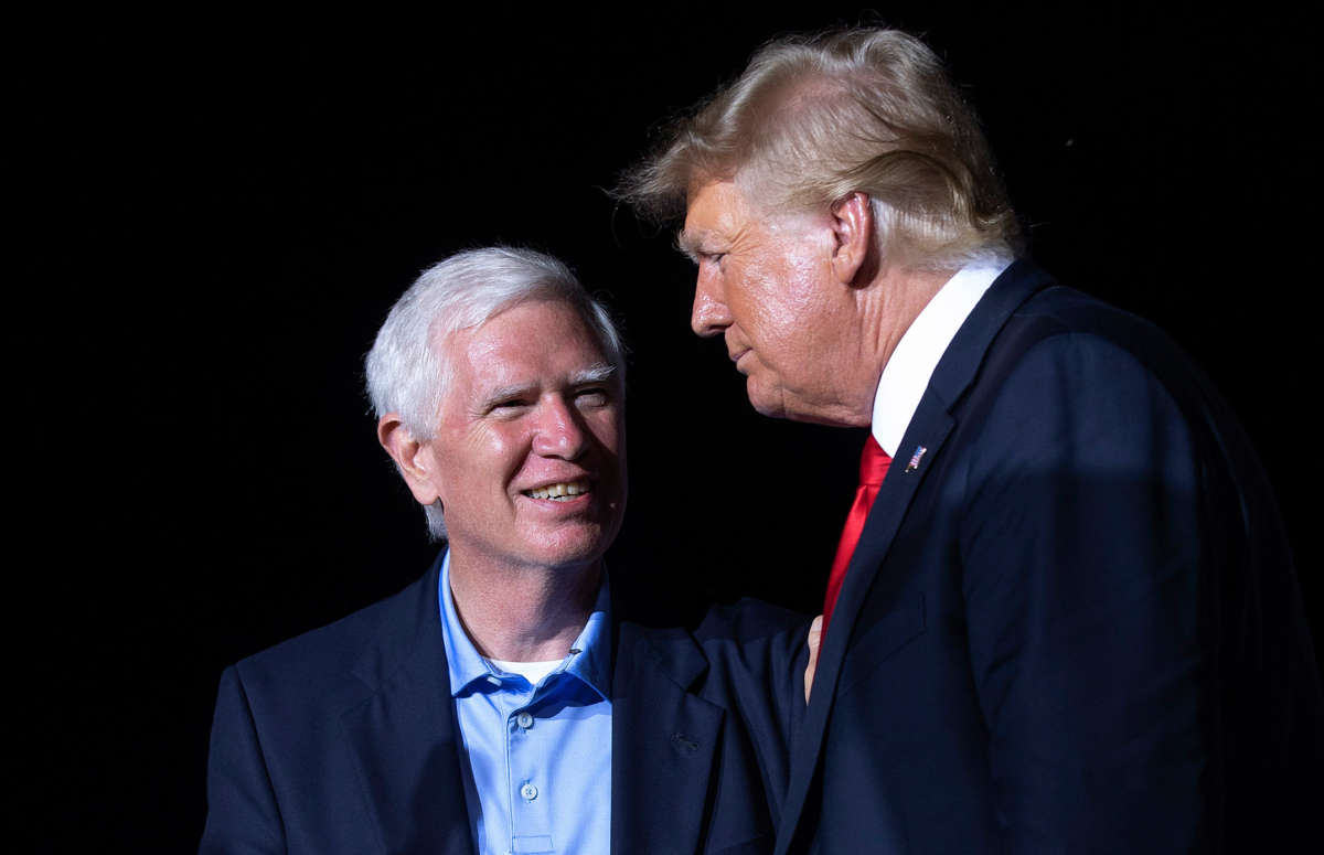 Former President Donald Trump (right) welcomes Rep. Mo Brooks to the stage during a rally at York Family Farms on August 21, 2021, in Cullman, Alabama.