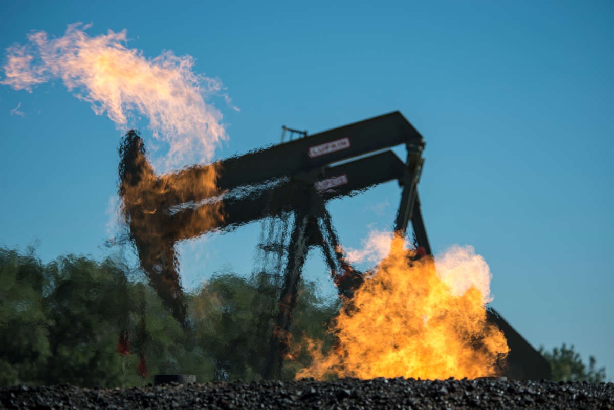 Flaring natural gas burns by jack pumps at an oil well near Buford, North Dakota, in the Bakken oil fields.