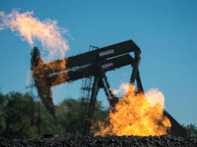 Flaring natural gas burns by jack pumps at an oil well near Buford, North Dakota, in the Bakken oil fields.
